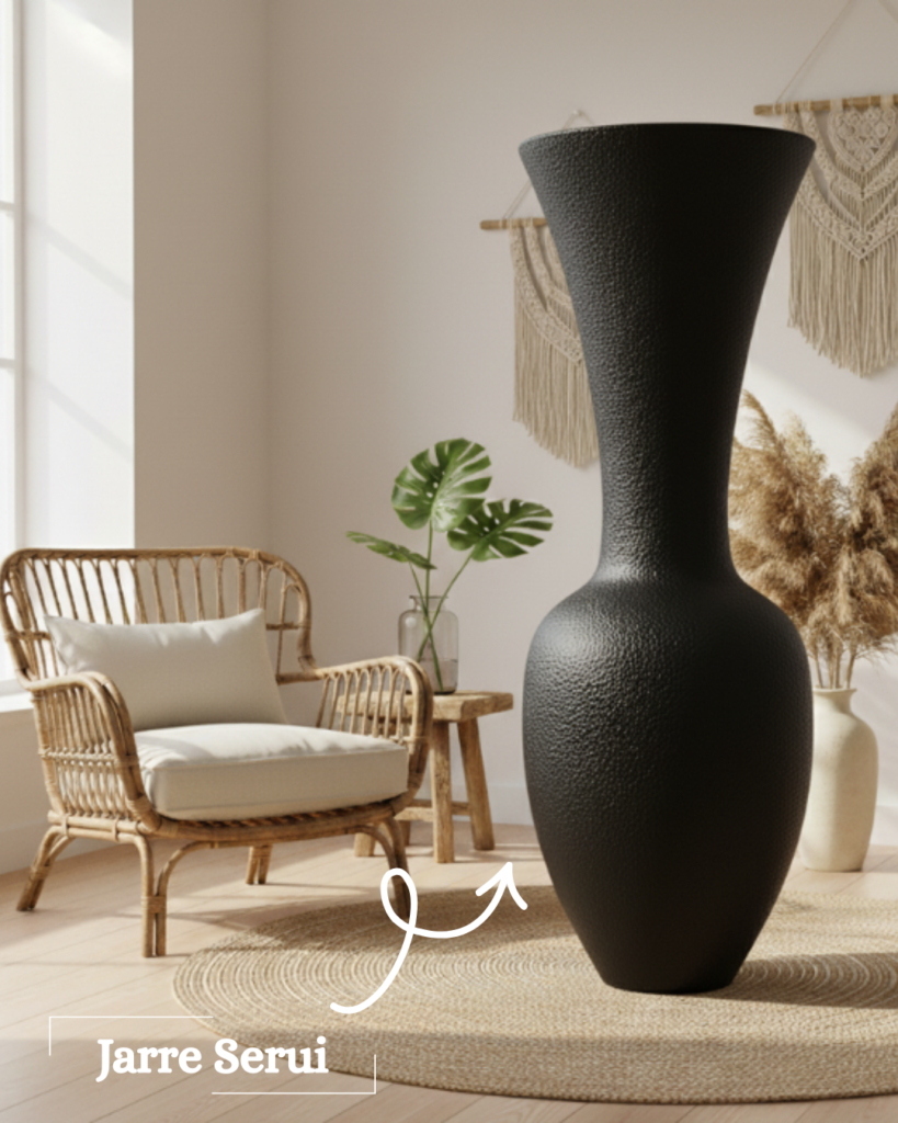Grande jarre décorative noire Serui au design sculptural dans un salon bohème avec fauteuil en rotin et tapis en fibres naturelles.