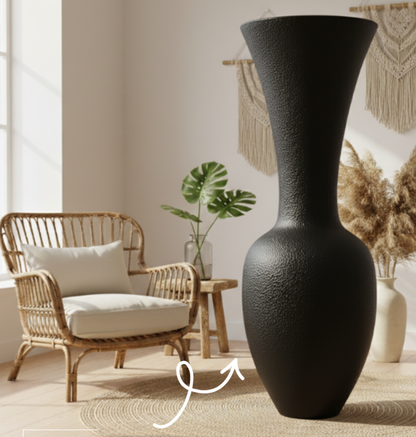 Grande jarre décorative noire Serui au design sculptural dans un salon bohème avec fauteuil en rotin et tapis en fibres naturelles.