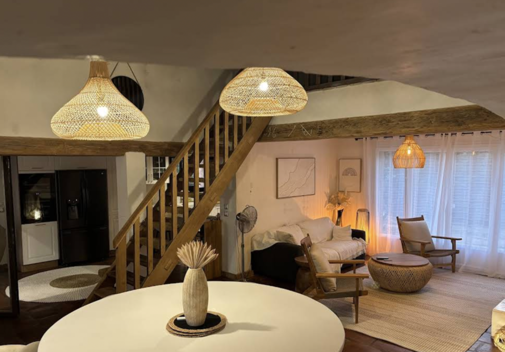 Salon bohème chic avec suspensions en rotin, mobilier en bois naturel et décoration aux matières naturelles.