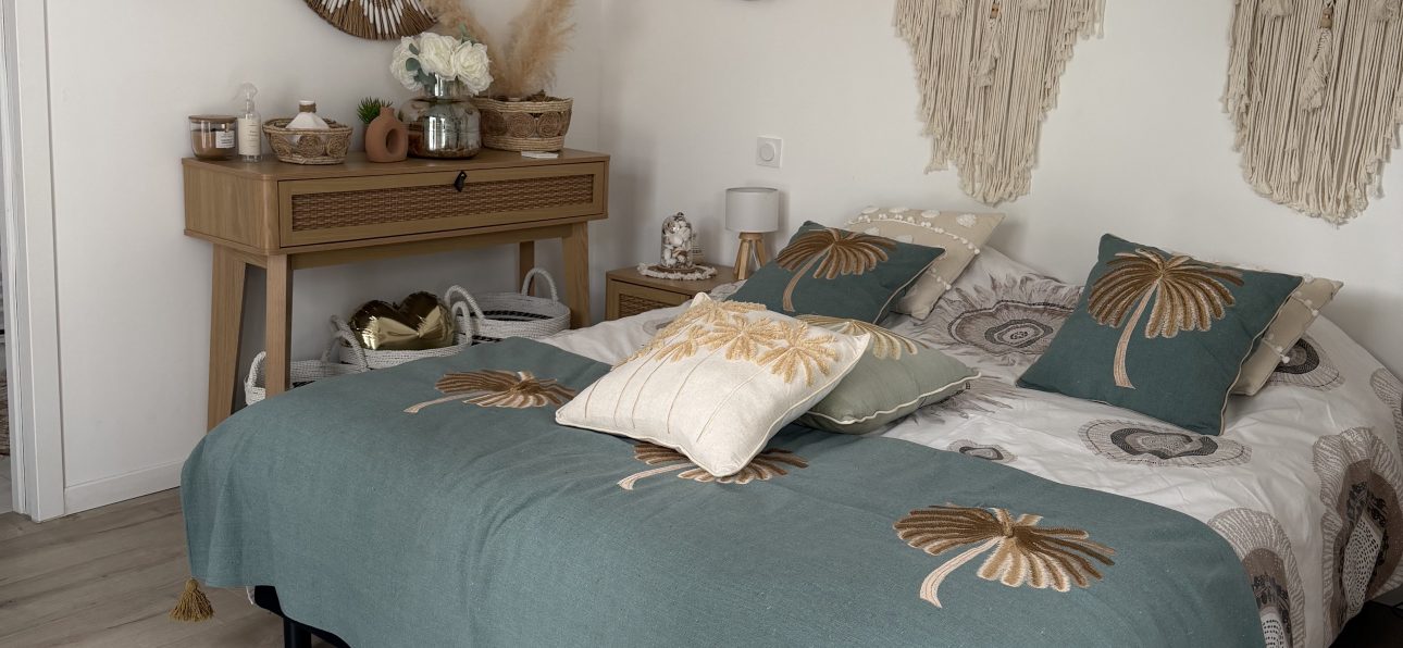 Chambre bohème adulte chaleureuse avec décoration murale en fibres naturelles, macramé et coussins aux tons verts et beiges, décoration bohème, esprit Quiet Luxury.