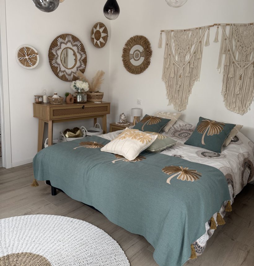 Chambre bohème adulte chaleureuse avec décoration murale en fibres naturelles, macramé et coussins aux tons verts et beiges, décoration bohème, esprit Quiet Luxury.