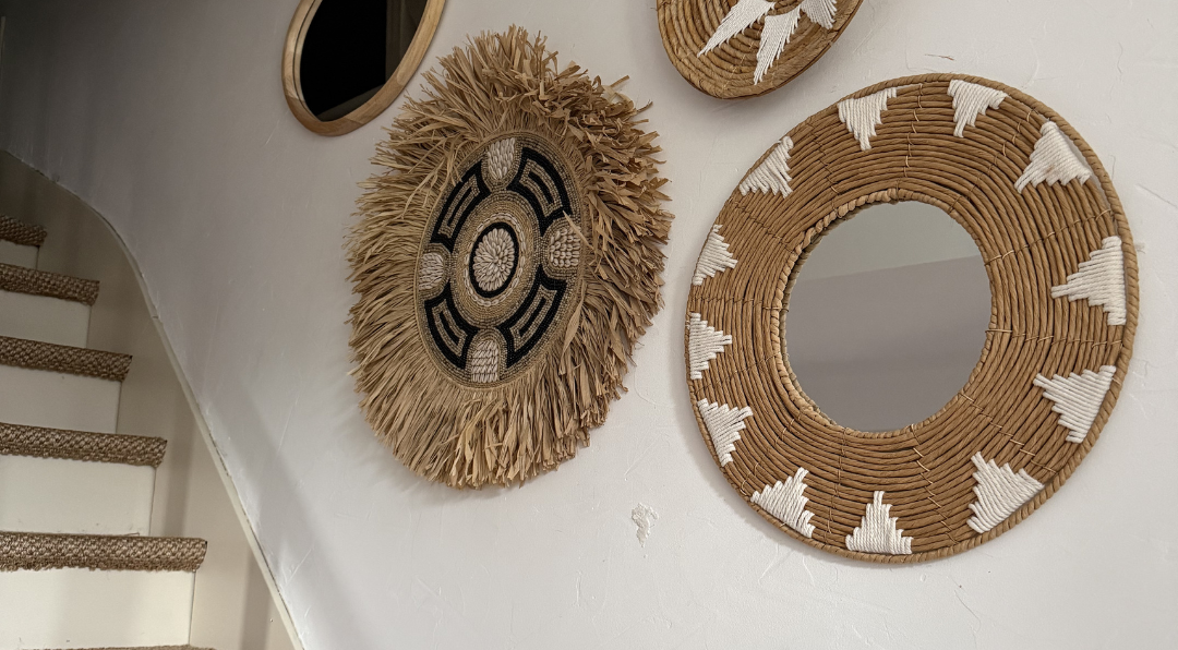 décoration murale bohème avec miroirs et éléments en fibres naturelles sur mur blanc