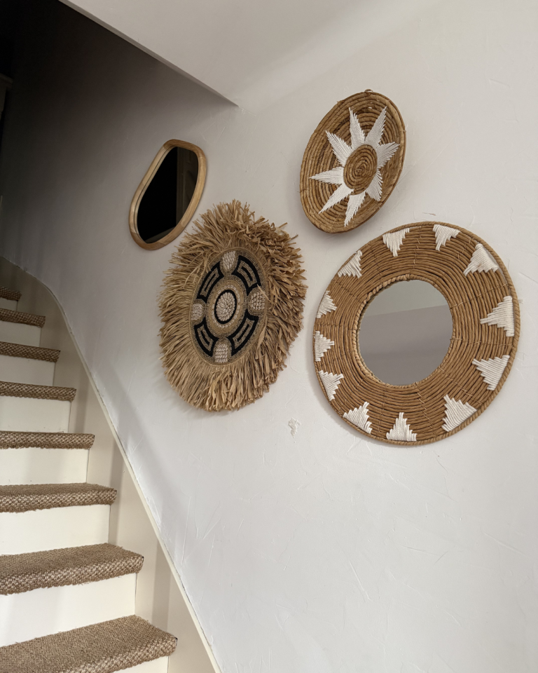 décoration murale bohème avec miroirs et éléments en fibres naturelles sur mur blanc
