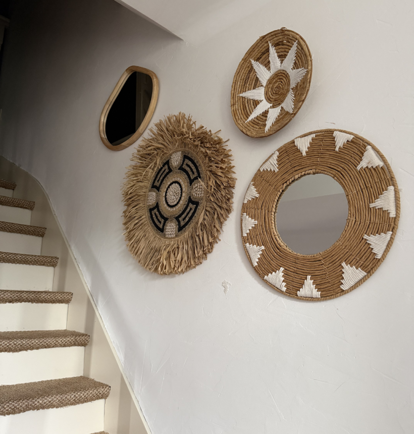 décoration murale bohème avec miroirs et éléments en fibres naturelles sur mur blanc