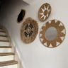 décoration murale bohème avec miroirs et éléments en fibres naturelles sur mur blanc