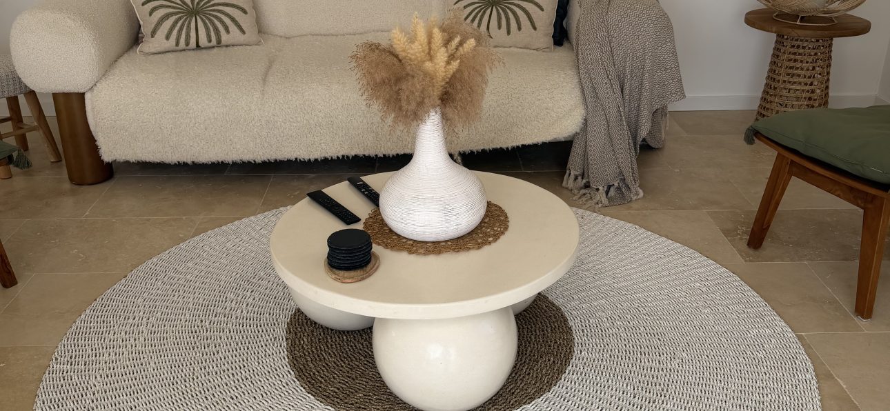 Salon équilibré évitant les erreurs déco bohème avec canapé clair, tapis rond en fibres naturelles et décoration épurée