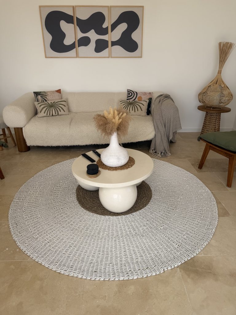 Salon équilibré évitant les erreurs déco bohème avec canapé clair, tapis rond en fibres naturelles et décoration épurée