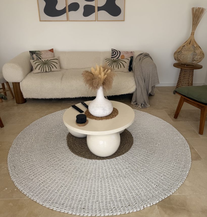 Salon équilibré évitant les erreurs déco bohème avec canapé clair, tapis rond en fibres naturelles et décoration épurée